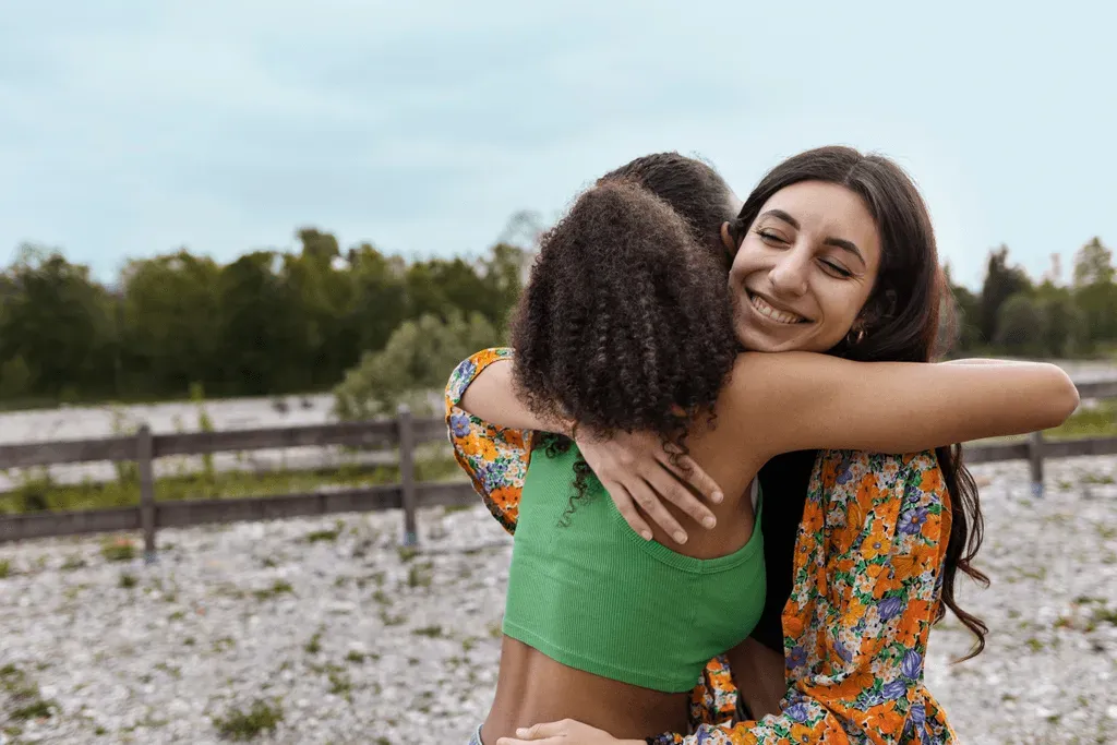 Duas jovens se abraçando ao ar livre